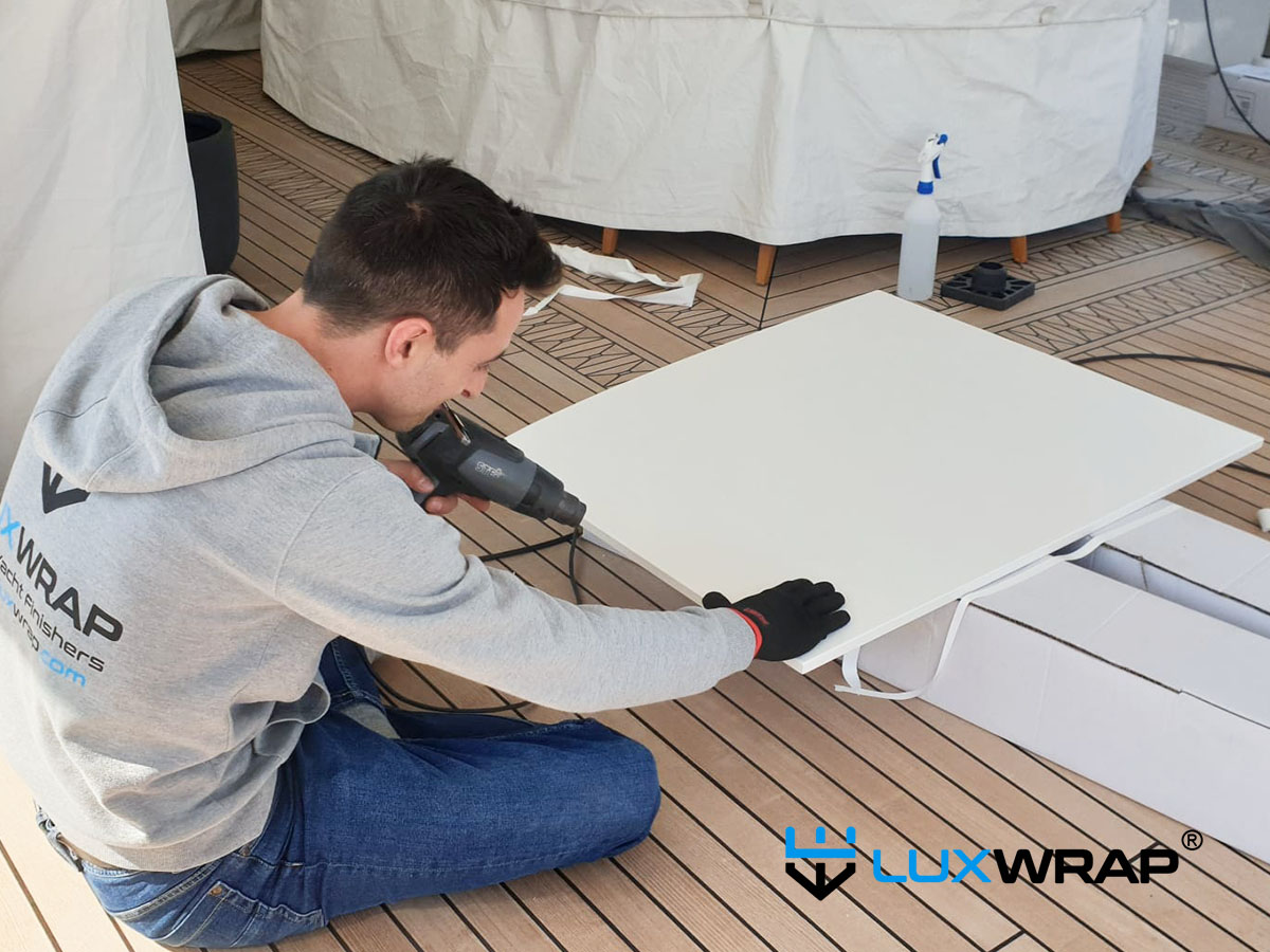 LuxWrap team wrapping superyacht deckhead panels onboard — a clean, dust-free alternative to painting