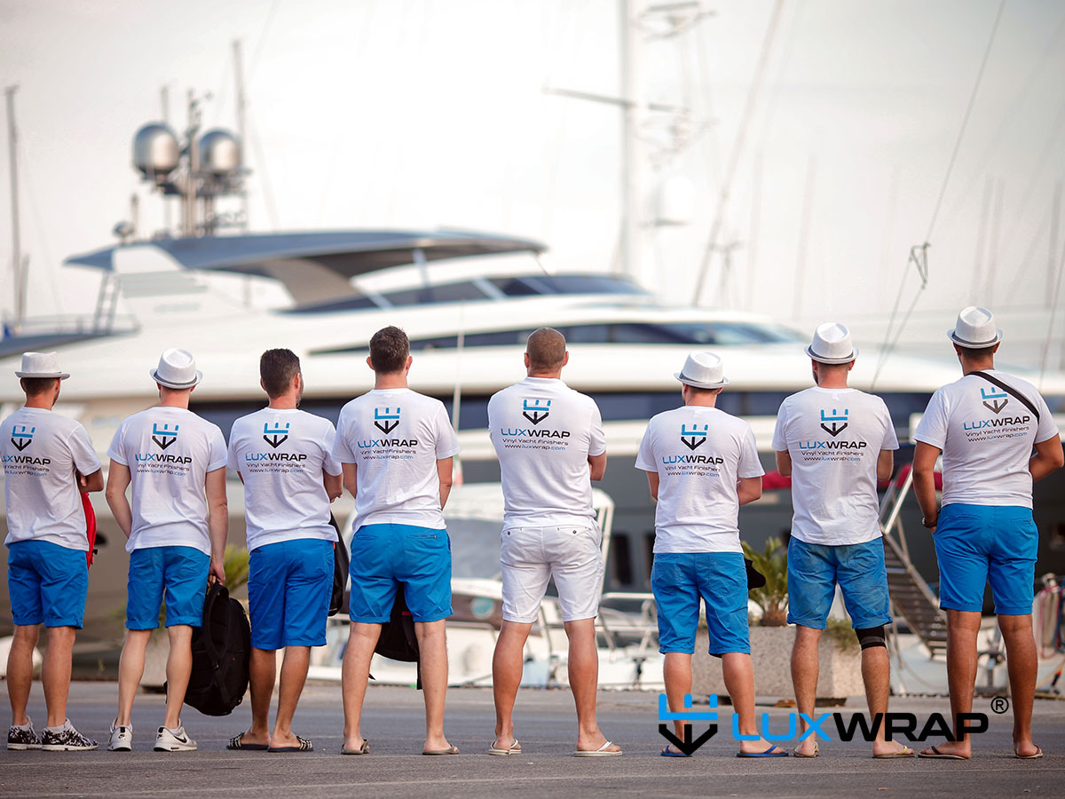 LuxWrap team standing in front of a superyacht preparing for wrapping project