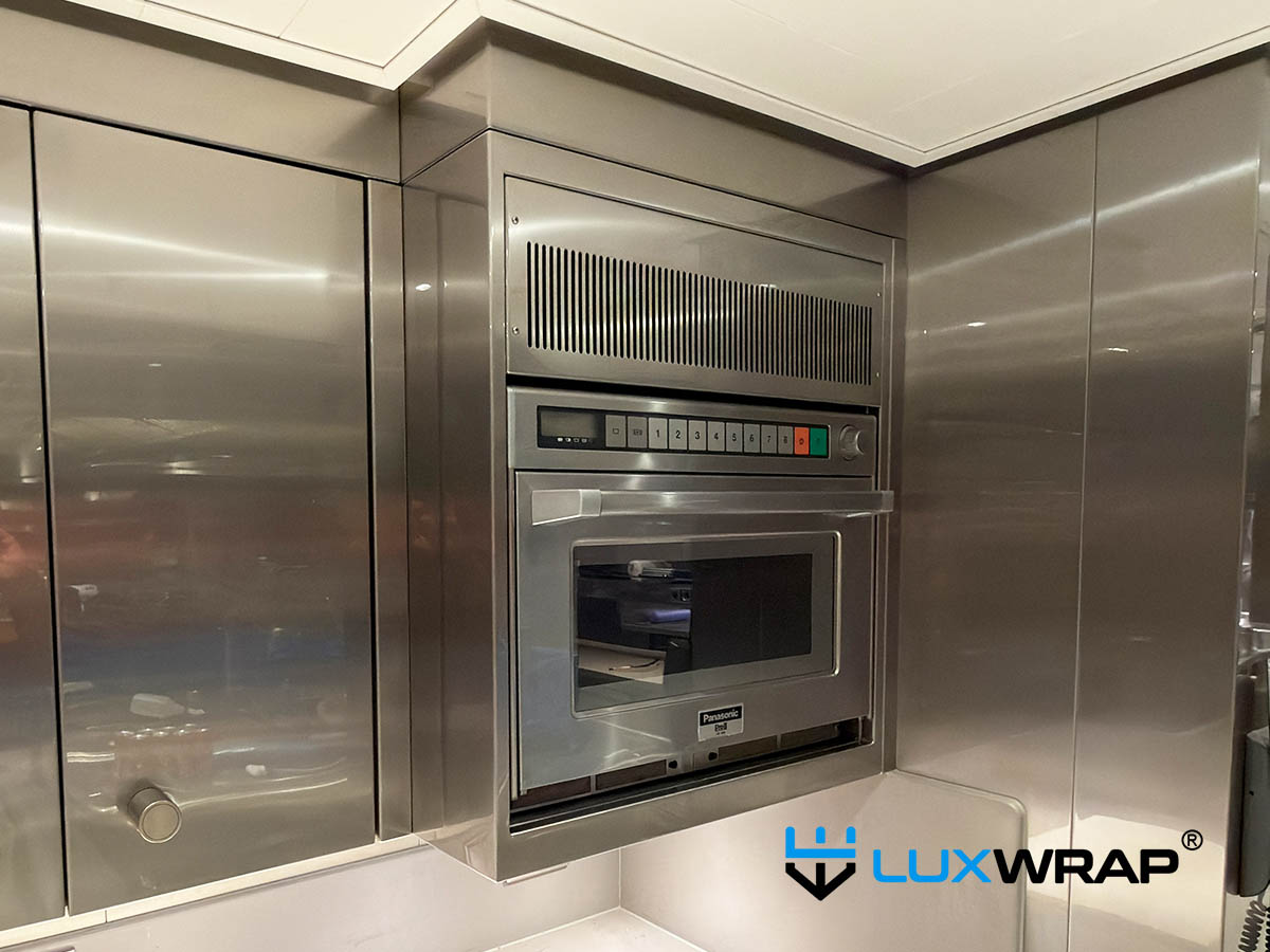 Superyacht galley wall units wrapped in ultra-gloss hygienic surface protection film to protect stainless steel and improve cleanability