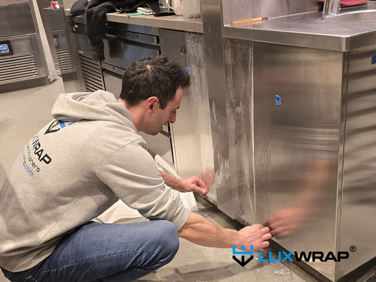 LuxWrap installation in progress — superyacht galley wrap in clear gloss ppf.