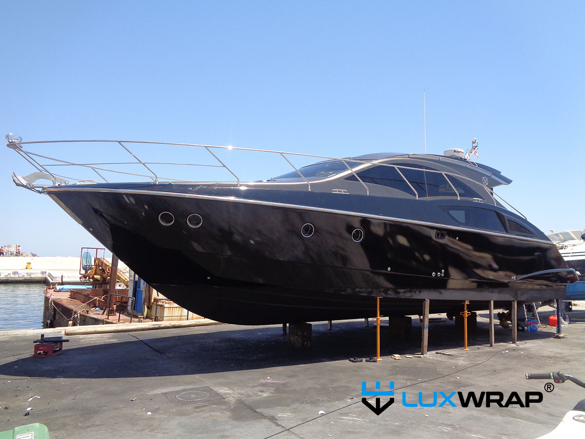 Finished small yacht wrapped in a full colour change — vessel positioned on hard standing during installation