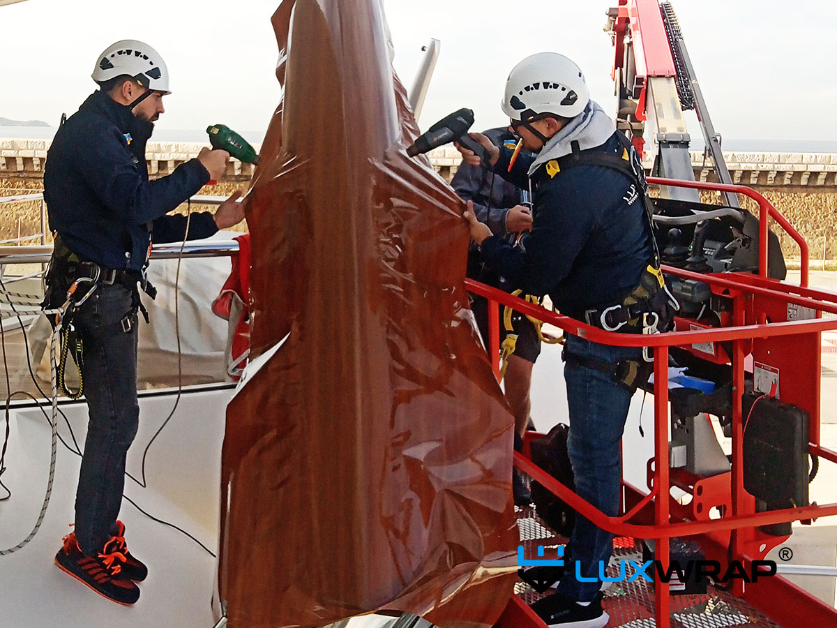 Faux wood grain vinyl wrap with NinjaShield PPF installed on a Feadship superyacht flagstaff — indistinguishable from varnished wood