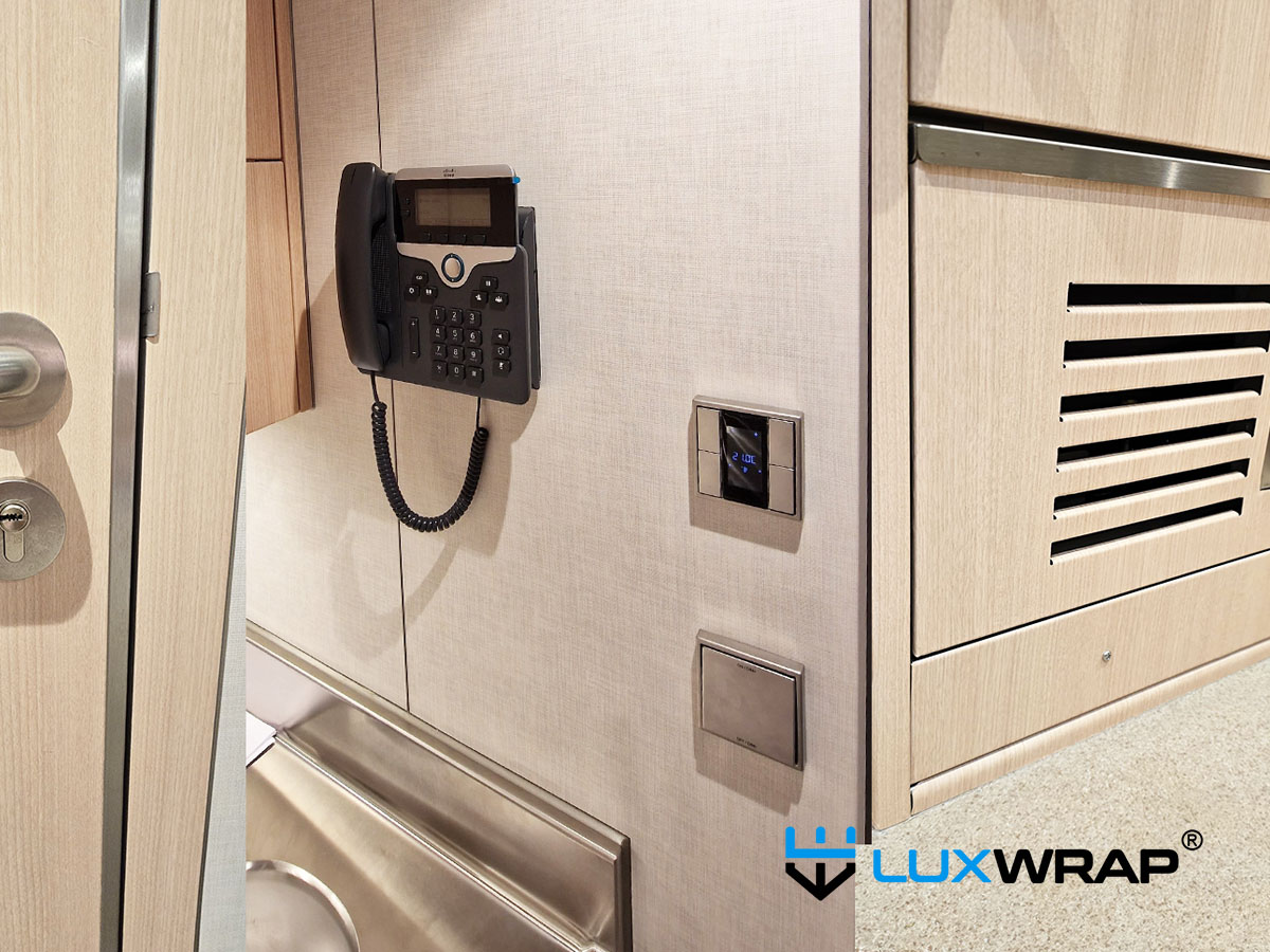 Completed superyacht galley interior wrap in wood grain vinyl — a realistic finish that surprises even experienced galley fabricators