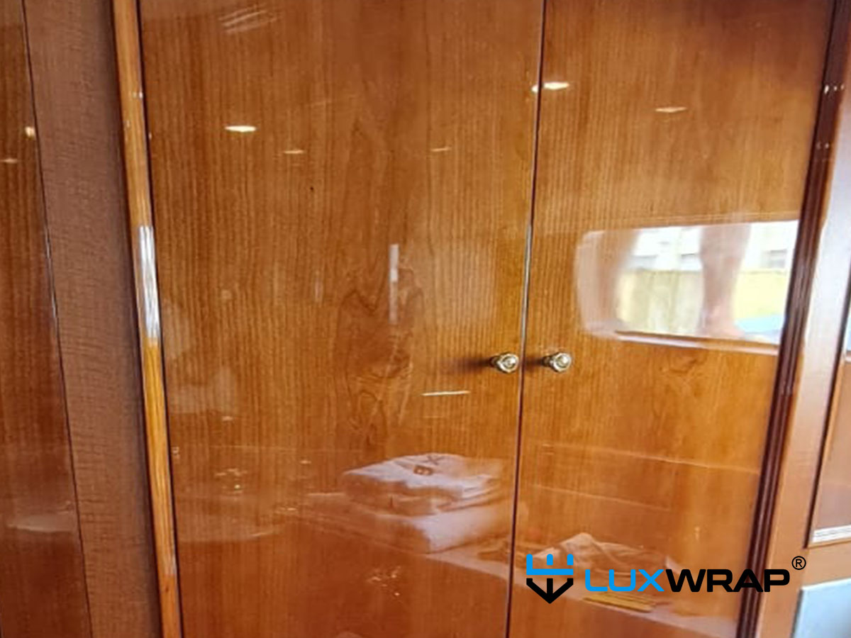 Superyacht interior wood surfaces refinished with vinyl and NinjaShield PPF — matching the original varnished wood gloss level